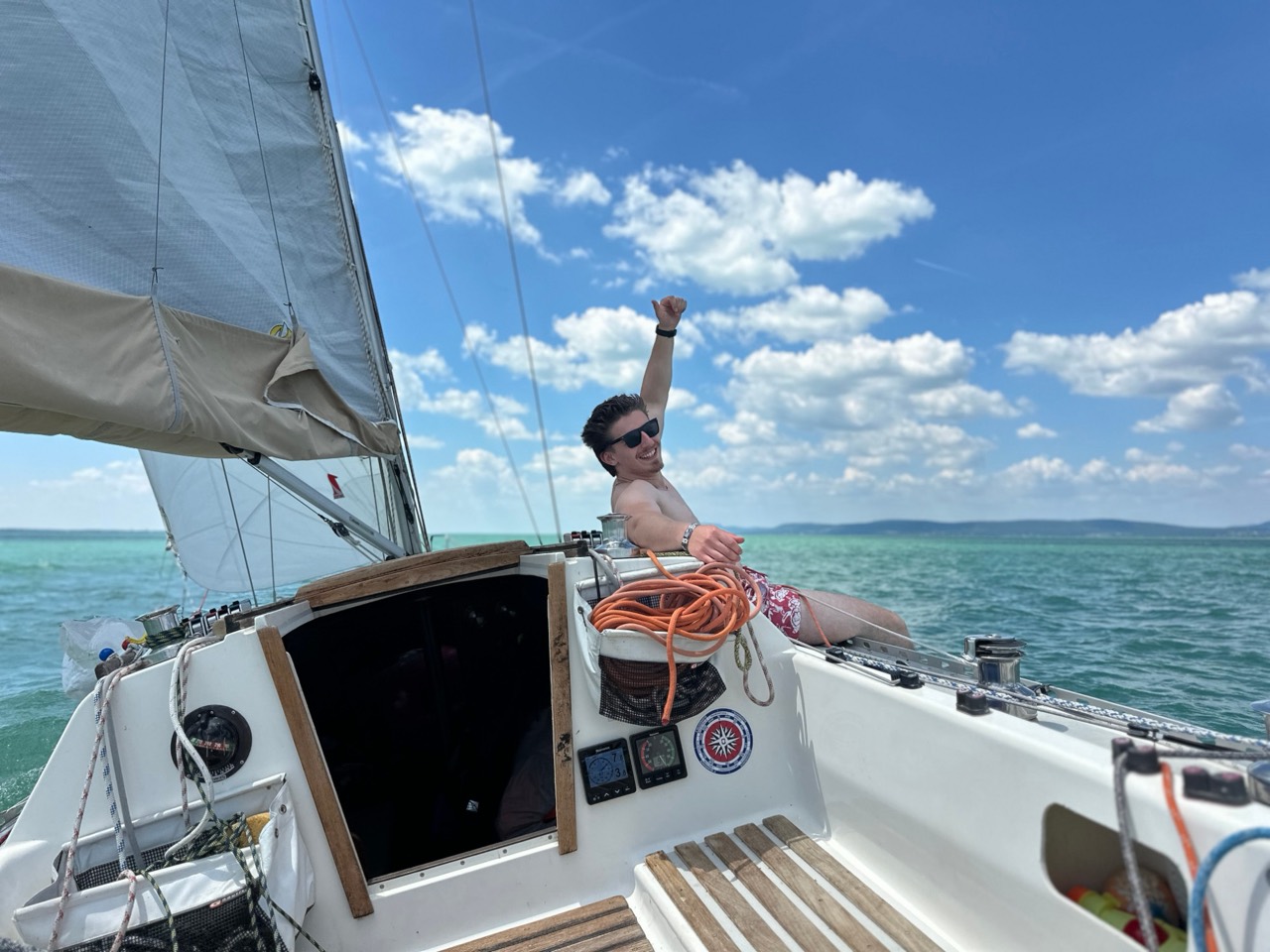 A guest aboard Jackpot on the turquoise water of Lake Balaton